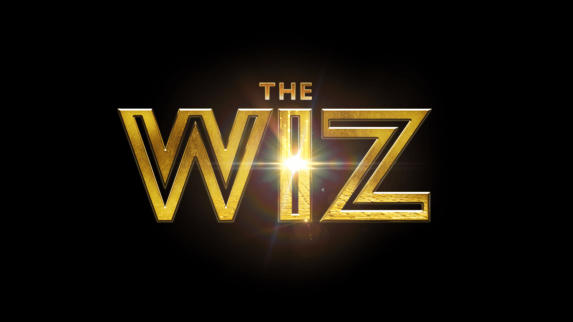 The words THE WIZ appear in large, bold, gold letters on a black background, with a bright light shining through the letter I in WIZ.