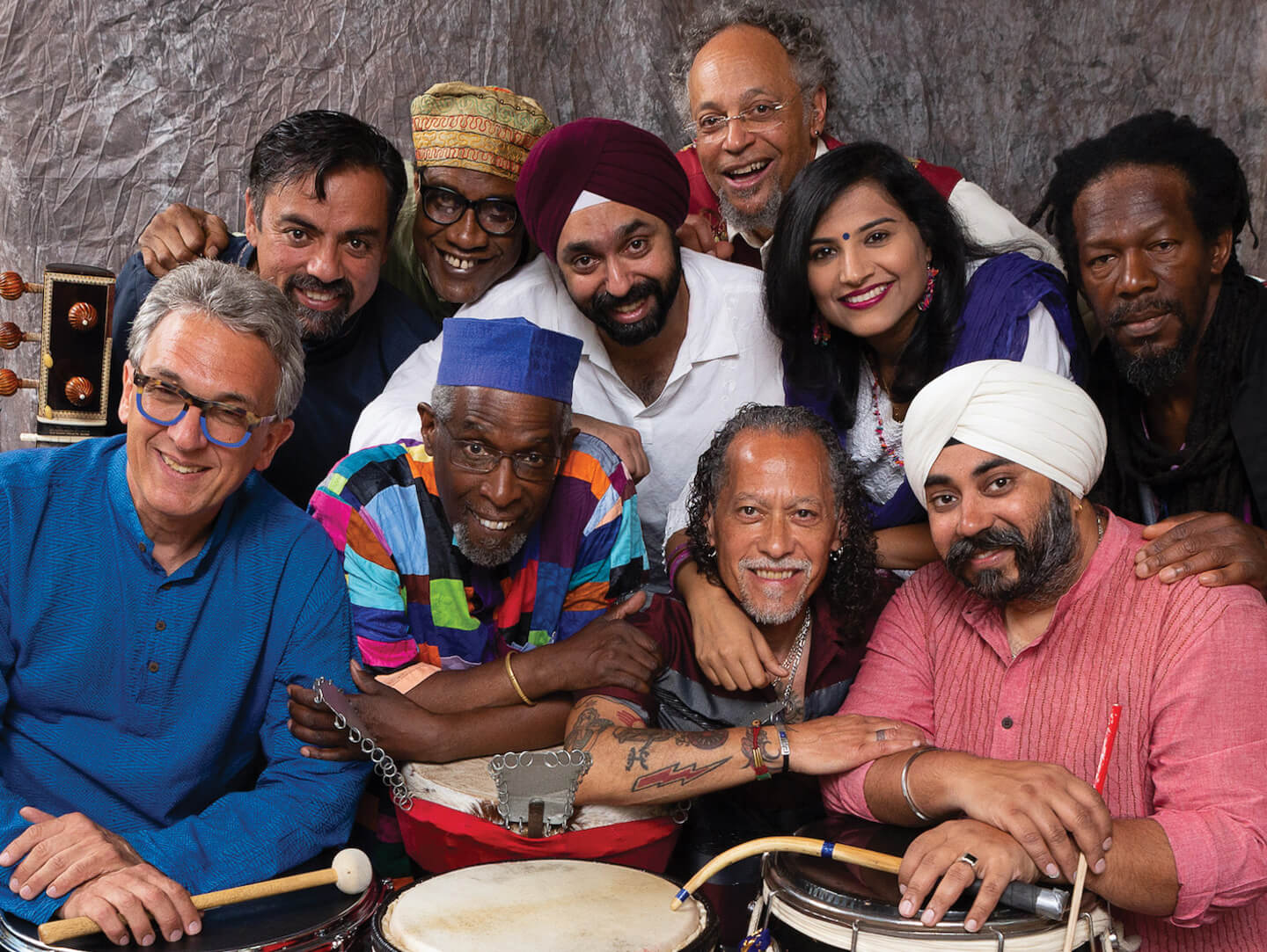 Balkan funk band Slavic Soul Party! members laying down in a circle holding their instruments